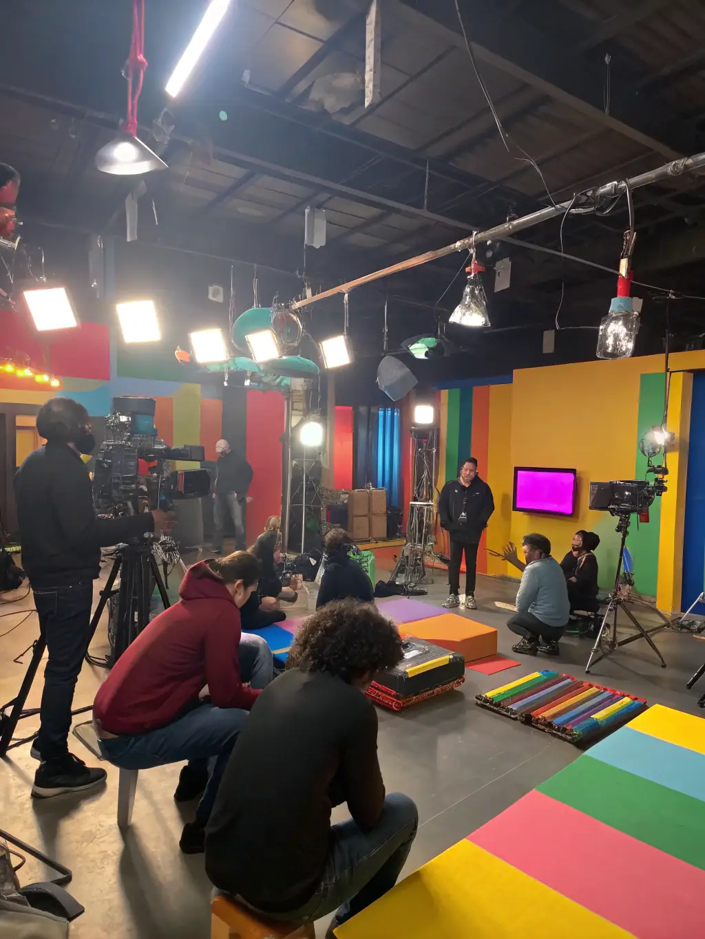 A photo of a group of young filmmakers participating in an EIGHTY PRODUCTION workshop, working with professional equipment and receiving guidance from instructors.